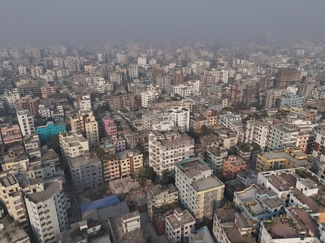 Aerial view of the dense urban landscape of Dhaka featuring a vast expanse of residential and commercial buildings narrow streets and a hazy atmosphere in Dhaka Dhaka Division Bangladesh. Aerial view of the dense urban landscape of Dhaka featuring a vast expanse of residential and commercial buildings narrow streets and a hazy atmosphere in Dhaka Dhaka Division Bangladesh.