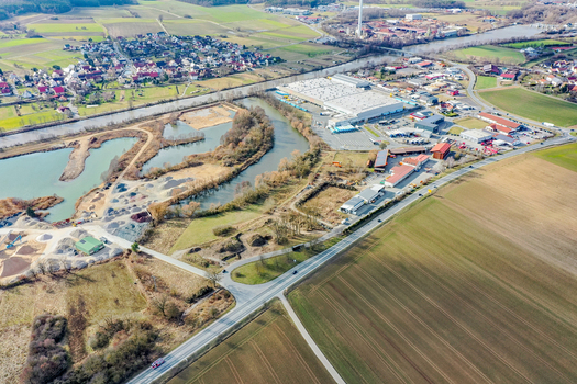 Aerial view of an industrial area and commercial buildings situated along a river surrounded by agricultural fields and a small village in Forchheim Bavaria Germany. Aerial view of an industrial area and commercial buildings situated along a river surrounded by agricultural fields and a small village in Forchheim Bavaria Germany.