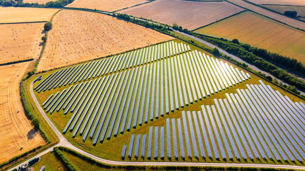 Aerial view of a large solar farm with rows of photovoltaic panels set in golden agricultural fields in Dorset England United Kingdom. Aerial view of a large solar farm with rows of photovoltaic panels set in golden agricultural fields in Dorset England United Kingdom.