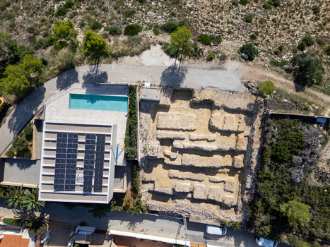 Aerial view of a modern villa with a swimming pool and solar panels situated next to an archaeological excavation site in Moraira Valencian Community Spain.