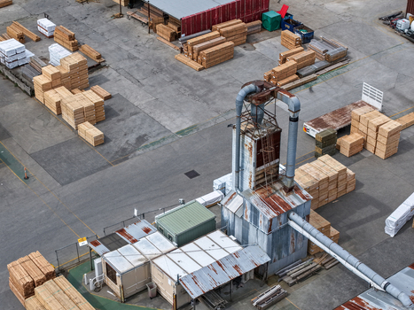 Melbourne VIC Australia 25 September 2026 Aerial view of a lumber yard featuring stacks of processed timber industrial machinery and corrugated metal structures.