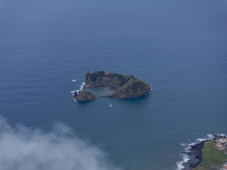 Aerial view of Ilheu de Vila Franca do Campo a volcanic islet with a natural circular crater lagoon surrounded by the deep blue Atlantic Ocean near the coast of Sao Pedro Acores Portugal. Aerial view of Ilheu de Vila Franca do Campo a volcanic islet with a natural circular crater lagoon surrounded by the deep blue Atlantic Ocean near the coast of Sao Pedro Acores Portugal.