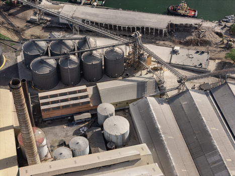 Aerial view of industrial port facility with large storage silos conveyor belt systems and factory buildings in Bajos de Haina San Cristobal Province Dominican Republic.