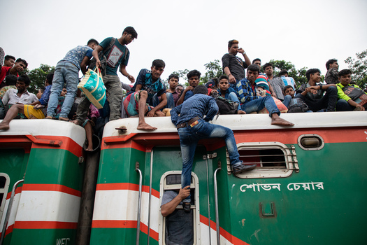 Dhaka Bangladesh 15 June 2018 View of people sitting on the roof and climbing on the sides of a crowded train at Airport Railway Station. Dhaka Bangladesh 15 June 2018 View of people sitting on the roof and climbing on the sides of a crowded train at Airport Railway Station.