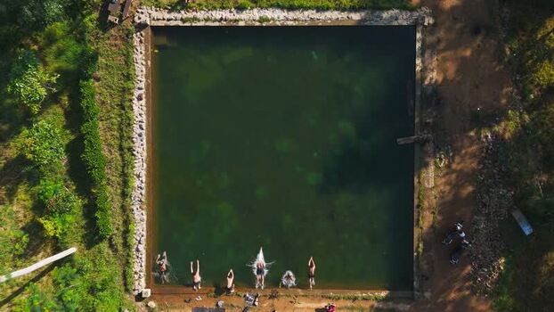 Aerial view of Embung Mbalong with people swimming Indonesia.