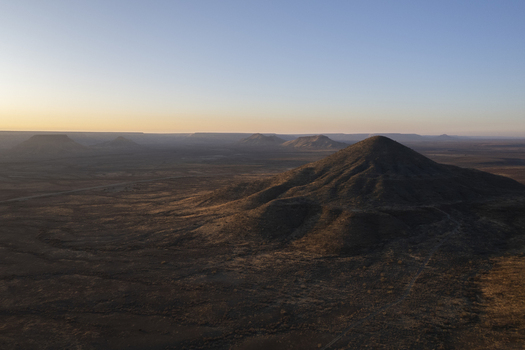Aerial view of the arid landscape unfolds with sun kissed peaks and shadows painting the earth in warm hues Windhoek Namibia. Aerial view of the arid landscape unfolds with sun kissed peaks and shadows painting the earth in warm hues Windhoek Namibia.