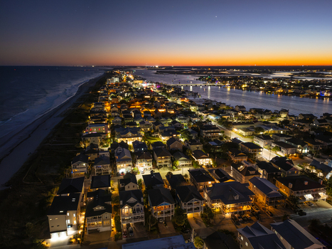 Aerial view of illuminated coastal homes along the shoreline at twilight in Wrightsville Beach North Carolina United States. Aerial view of illuminated coastal homes along the shoreline at twilight in Wrightsville Beach North Carolina United States.