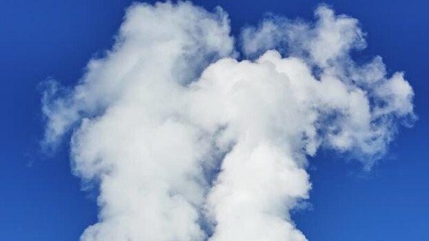 Aerial view of white smoke rising into a blue sky Austria.