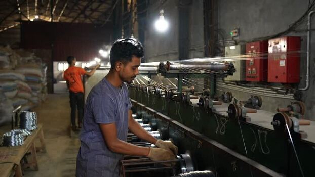 View of workers operating machinery in a factory Bangladesh.