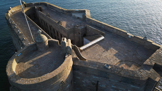 Aerial view of the imposing Château du Taureau a stone fortress bathed in the soft glow of the sun standing firm against the endless blue sea Plouezoc h Bretagne France. Aerial view of the imposing Château du Taureau a stone fortress bathed in the soft glow of the sun standing firm against the endless blue sea Plouezoc h Bretagne France.