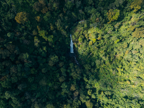Aerial view of Khun Korn Waterfall cascading through a lush tropical jungle with dense green tree canopies in Tambon Huai Chomphu Chang Wat Chiang Rai Thailand. Aerial view of Khun Korn Waterfall cascading through a lush tropical jungle with dense green tree canopies in Tambon Huai Chomphu Chang Wat Chiang Rai Thailand.