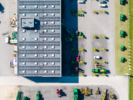 Aerial view of a farm equipment supplier facility with rooftop solar panels green tractors in the parking lot and various agricultural machinery in Kekava Kekava Municipality Latvia. Aerial view of a farm equipment supplier facility with rooftop solar panels green tractors in the parking lot and various agricultural machinery in Kekava Kekava Municipality Latvia.