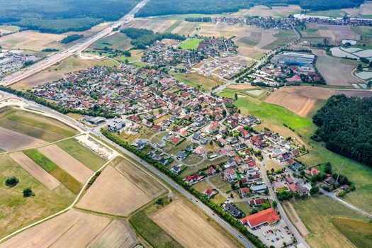 Aerial view of Hessdorf featuring residential houses vast agricultural fields and a major highway in Hessdorf Bavaria Germany.