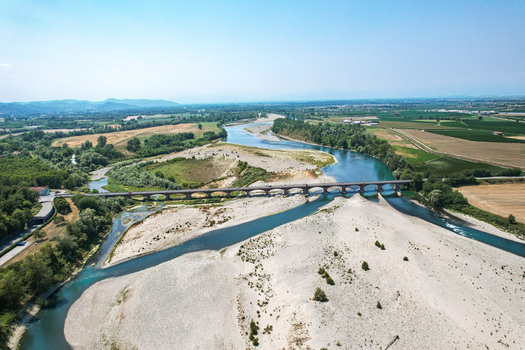 Aerial view of Ponte Crescentino crossing the Po river during a severe drought with exposed gravel riverbeds and surrounding agricultural fields in Verrua Savoia Piemonte Italy. Aerial view of Ponte Crescentino crossing the Po river during a severe drought with exposed gravel riverbeds and surrounding agricultural fields in Verrua Savoia Piemonte Italy.