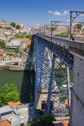 Porto Portugal 13 July 2021 View of the Dom Luís I Bridge a metallic marvel spanning the Douro River connecting the vibrant cityscape under a clear blue sky. Porto Portugal 13 July 2021 View of the Dom Luís I Bridge a metallic marvel spanning the Douro River connecting the vibrant cityscape under a clear blue sky.