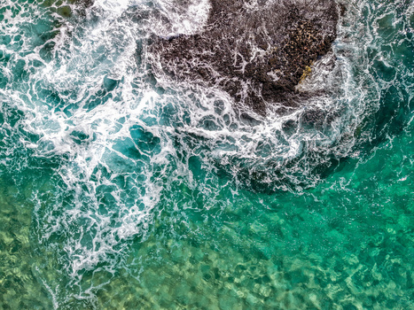 Aerial view of Cudgen Headland South Head with turquoise ocean water and white sea foam crashing against dark rocks in Kingscliff New South Wales Australia. Aerial view of Cudgen Headland South Head with turquoise ocean water and white sea foam crashing against dark rocks in Kingscliff New South Wales Australia.