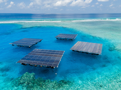Aerial view of SolarSea floating solar power plant platforms on turquoise lagoon water near a coral reef in Dharavandhoo Baa Atoll Maldives. Aerial view of SolarSea floating solar power plant platforms on turquoise lagoon water near a coral reef in Dharavandhoo Baa Atoll Maldives.