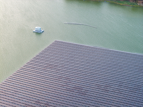 Aerial view of the floating solar farm at Sutami Dam in Karangkates with rows of photovoltaic panels on the water surface in Kecamatan Sumberpucung Jawa Timur Indonesia. Aerial view of the floating solar farm at Sutami Dam in Karangkates with rows of photovoltaic panels on the water surface in Kecamatan Sumberpucung Jawa Timur Indonesia.