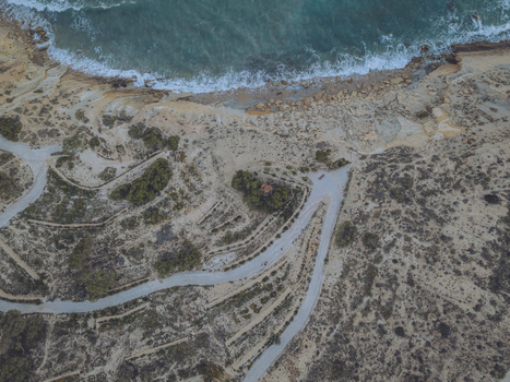 Aerial view of Santuari iber i roma de la Malladeta archaeological site with winding paths and rugged cliffs overlooking the turquoise sea La Vila Joiosa Comunidad Valenciana Spain. Aerial view of Santuari iber i roma de la Malladeta archaeological site with winding paths and rugged cliffs overlooking the turquoise sea La Vila Joiosa Comunidad Valenciana Spain.