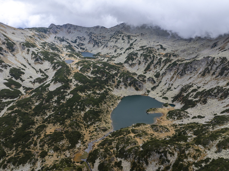 Aerial view of Muratovo Lake surrounded by the rocky peaks and alpine vegetation of Pirin National Park in Blagoevgrad Province Bulgaria. Aerial view of Muratovo Lake surrounded by the rocky peaks and alpine vegetation of Pirin National Park in Blagoevgrad Province Bulgaria.