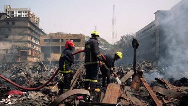 View of firefighters working at a fire scene in Dhaka Bangladesh. View of firefighters working at a fire scene in Dhaka Bangladesh.