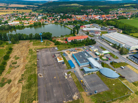 Aerial view of the industrial area and town of Zebrak with a pond and the historic Zebrak Castle in the distance surrounded by green fields in Zebrak Central Bohemian Region Czechia. Aerial view of the industrial area and town of Zebrak with a pond and the historic Zebrak Castle in the distance surrounded by green fields in Zebrak Central Bohemian Region Czechia.