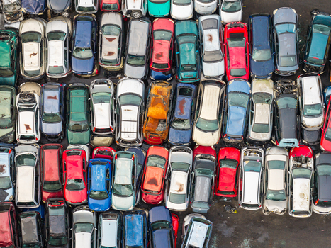 Aerial view of an end of life vehicle recycling facility with rows of salvaged cars in various colors and states of disrepair parked on a paved lot in Gdansk Pomeranian Voivodeshi Poland.