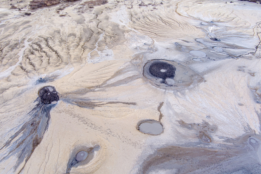 Aerial view of the Mud Volcanoes of Paclele Mari showing unique geological formations with bubbling mud craters and textured landscape in Paclele Buzau County Romania.
