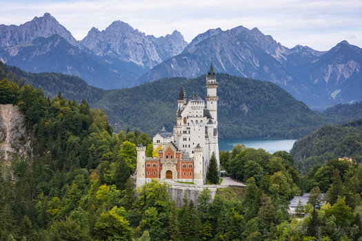 Aerial view of fairytale Neuschwanstein Castle nestled among vibrant green forests and majestic mountains Neuschwanstein Castle Bayern Germany. Aerial view of fairytale Neuschwanstein Castle nestled among vibrant green forests and majestic mountains Neuschwanstein Castle Bayern Germany.