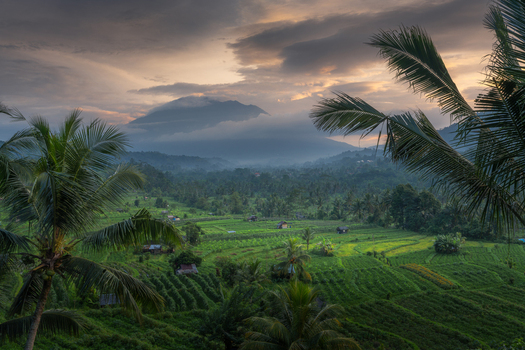 Aerial view of the Sidemen rice terraces and tropical valley with Mount Agung in the background under a dramatic sunset sky Sidemen Bali Indonesia. Aerial view of the Sidemen rice terraces and tropical valley with Mount Agung in the background under a dramatic sunset sky Sidemen Bali Indonesia.