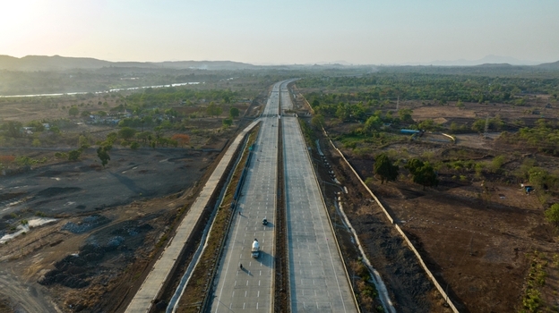 Aerial view of the JNPT highway near Badlapur featuring a multi lane concrete road stretching through a rural landscape under a clear sky Badlapur Maharashtra India. Aerial view of the JNPT highway near Badlapur featuring a multi lane concrete road stretching through a rural landscape under a clear sky Badlapur Maharashtra India.