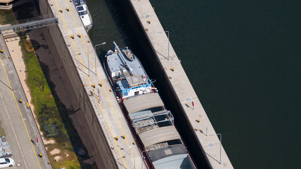 Aerial view of the Neckar Staustufe und Schleuse Rockenau with a cargo ship navigating the lock chamber in Eberbach Baden Wurttemberg Germany. Aerial view of the Neckar Staustufe und Schleuse Rockenau with a cargo ship navigating the lock chamber in Eberbach Baden Wurttemberg Germany.