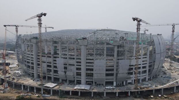 Aerial view of Jakarta International Stadium under construction with tall cranes surrounding the massive concrete structure in Tanjung Priok Jakarta Indonesia. Aerial view of Jakarta International Stadium under construction with tall cranes surrounding the massive concrete structure in Tanjung Priok Jakarta Indonesia.