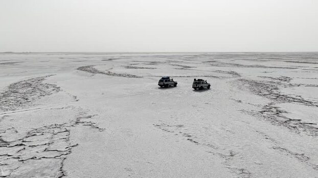 Aerial view of two off road vehicles driving across Danakil Desert Ethiopia. Aerial view of two off road vehicles driving across Danakil Desert Ethiopia.
