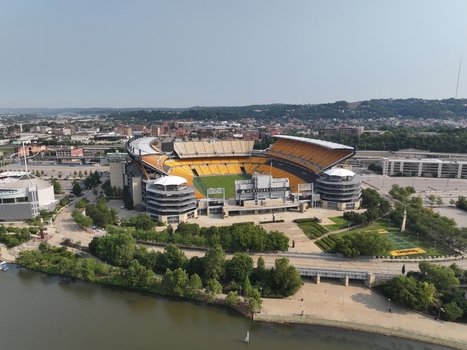 Pittsburgh Pennsylvania United States 26 July 2026 Aerial view of Acrisure Stadium situated along the river with surrounding urban infrastructure lush trees and clear sky.