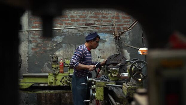 View of a worker operating a lathe machine in Kushtia Bangladesh.