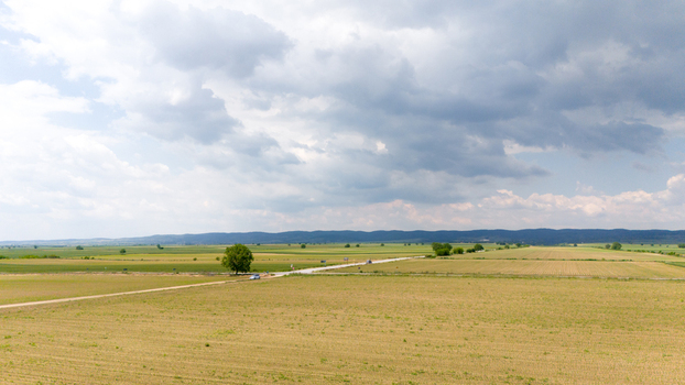Aerial view of vast agricultural fields and a straight rural road under a dramatic cloudy sky Novi Sad Vojvodina Serbia. Aerial view of vast agricultural fields and a straight rural road under a dramatic cloudy sky Novi Sad Vojvodina Serbia.