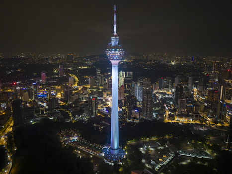 Kuala Lumpur Malaysia 11 March 2026 Aerial view of the illuminated Kuala Lumpur Tower at night surrounded by the city skyline and dark parkland.