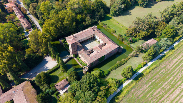 Aerial view of Castello di Peschiera Borromeo surrounded by a moat lush green trees and agricultural fields in Peschiera Borromeo Lombardia Italy. Aerial view of Castello di Peschiera Borromeo surrounded by a moat lush green trees and agricultural fields in Peschiera Borromeo Lombardia Italy.