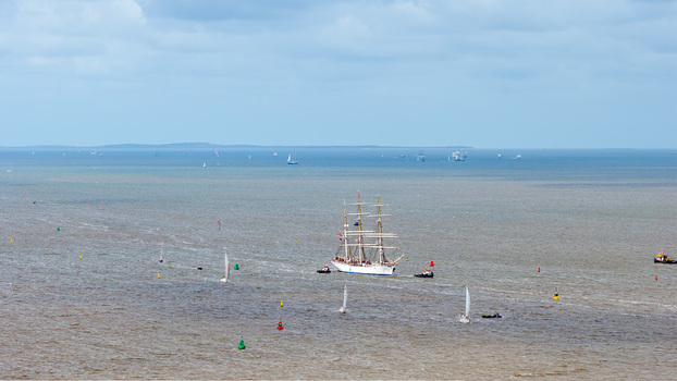 Aerial view of a tall ship participating in The Tall Ships Races Harlingen surrounded by smaller sailboats and navigation buoys in the Wadden Sea. Harlingen Friesland Netherlands.