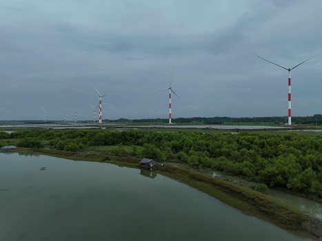 Aerial view of Khurushkul wind farm with red and white turbines standing over lush green mangroves and calm water bodies in Cox s Bazar Chittagong Division Bangladesh. Aerial view of Khurushkul wind farm with red and white turbines standing over lush green mangroves and calm water bodies in Cox s Bazar Chittagong Division Bangladesh.