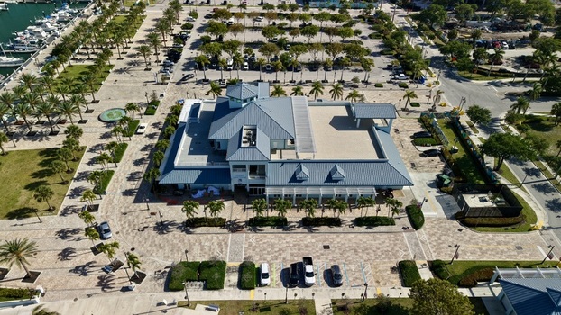 Aerial view of the Riviera Beach Marina Village building with its blue roof surrounded by palm trees and paved walkways in Riviera Beach Florida United States. Aerial view of the Riviera Beach Marina Village building with its blue roof surrounded by palm trees and paved walkways in Riviera Beach Florida United States.