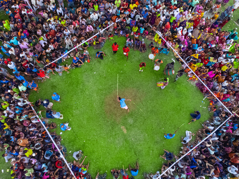 Nilphamari Bangladesh 01 May 2026 Aerial view of a traditional folk game performance in a green field surrounded by a large crowd of spectators and musicians. Nilphamari Bangladesh 01 May 2026 Aerial view of a traditional folk game performance in a green field surrounded by a large crowd of spectators and musicians.