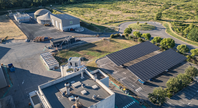 Aerial view of an industrial facility featuring solar photovoltaic carports and a biogas plant in Le Pouzin Auvergne Rhone Alpes France.
