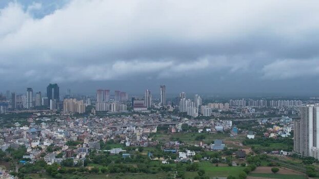 Aerial view of Gurugram skyscrapers and monsoon clouds India.