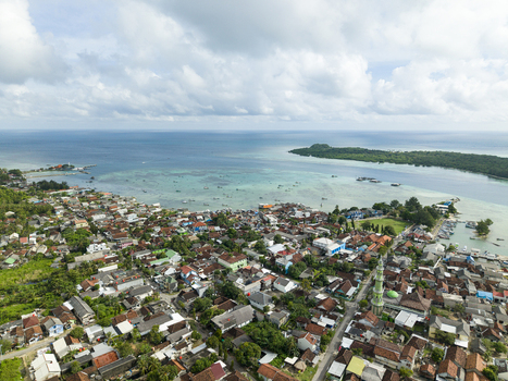 Aerial view of a vibrant coastal town nestled between lush greenery and turquoise waters Karimunjawa Central Java Indonesia. Aerial view of a vibrant coastal town nestled between lush greenery and turquoise waters Karimunjawa Central Java Indonesia.