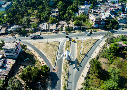 Aerial view of a MiG 21 fighter jet monument situated at a road intersection surrounded by urban buildings and greenery in Rajshahi Rajshahi Division Bangladesh.