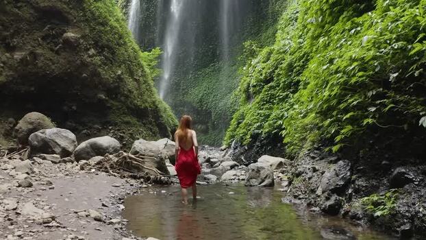 Aerial view of Madakaripura Waterfall and a woman in a red dress Indonesia. Aerial view of Madakaripura Waterfall and a woman in a red dress Indonesia.