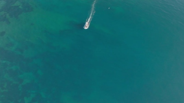 Aerial view of a boat cruising near Island of Ortigia Italy. Aerial view of a boat cruising near Island of Ortigia Italy.