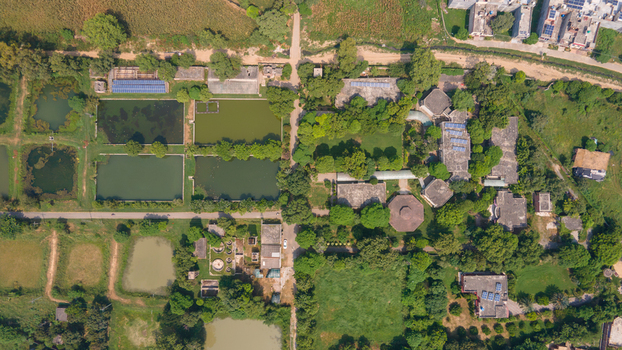 Aerial view of a fishing farm with rectangular ponds lush greenery and buildings with solar panels in Punjab Pakistan. Aerial view of a fishing farm with rectangular ponds lush greenery and buildings with solar panels in Punjab Pakistan.